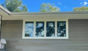Four new windows installed next to each other on the side of a house.